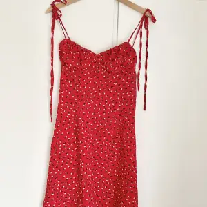Röd blommig klänning med justerbara band☺️dragskejda på sidan.
