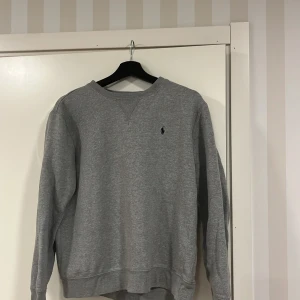Grå Ralph lauren sweatshirt  - Säljer min grå Ralph lauren sweatshirt för att den har blivit lite för liten och inte används lika mycket längre. Köpt på kids brandstore kvitto finns ej. Skriv för mer bilder och pris kan diskuteras.