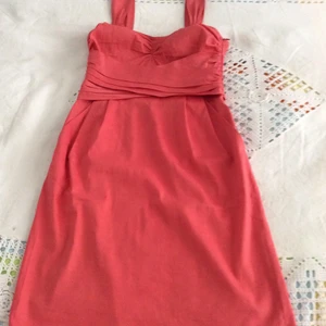 Klänning DKNY i storlek US 4 (EU 36) - Sommarklänning i fin langust/peach färg. Materialet (Bomull/lin) gör att klänningen känns sval och luftig. Vanlig passform 