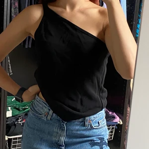 Oneshoulder topp - Svart oneshoulder topp i tjockt material. Aldrig använd och saknar både storlek och märke, den är stor på mig som vanligtvis har xs. Säljer för 49kr + frakt 🚚! Skriv vid intresse eller frågor! 