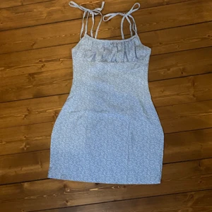 Jättefin blå klänning💙 - Fin blå klänning med vita blommor💙 Den är rätt så kurvig i sidorna som man ser på bilden. Aldrig använd och i fint skick!