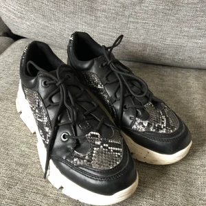 Sneakers med platå i strl 41 - Sneakers med platå och ormskinnsmotiv. Använda några gånger så är i fint skick. 