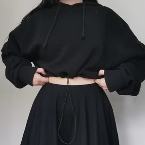Croppad hoodie  - Croppad hoodie med fickor på armarna och band man kan dra åt vid midjan. 