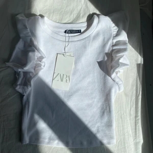 Volangtopp från zara! - Jättefin topp ifrån zara. Köpt förra sommaren men aldrig använd, därav är lappen kvar. Säljer för att den inte kommer till användning.