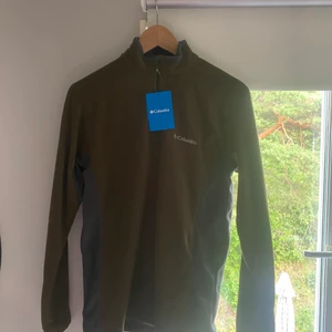 Columbia fleece - Helt ny half-zip fleece från Columbia som aldrig kommit till användning. Perfekt som skidunderställ eller som vanlig fleece kofta, storleken är XS i man men passar även S i damstorlek (passar mig som är S).