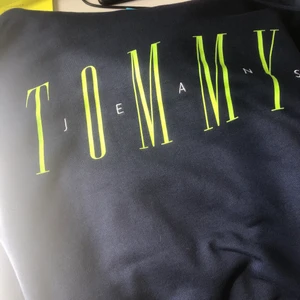 Tommy Hilfiger hoodie - Använd 1 gång, helt i nyskick. Fin mörkblå färg med ljusgrönt tryck. Inga fickor.
