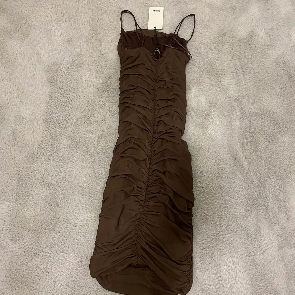 En snygg brun klänning från bikbok som är köpt förra året och helt oanvänd i storlek S. Klänningar.