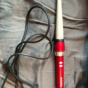 Babyliss locktång - Röd locktång med anpassningsbar värme och inbyggt stöd att luta den med när den ska svalna. Använd men i fint skick.  Kan skickas mot fraktkostnad eller beroende på plats mötas upp. 