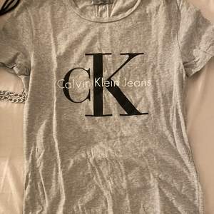 En grå T-shirt men calvin Klein jeans tryck på bröstet. Är i bra skick och använd fåtal gånger