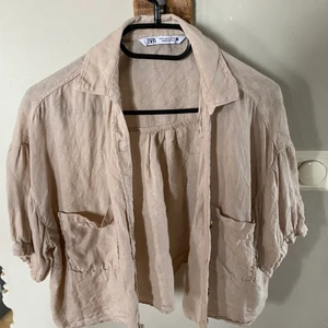 Beige skjorta - En kortärmad skjorta som är kort modell, slutar vid navlen. Är knappt använd och är väldigt skön och går att matcha me allt 