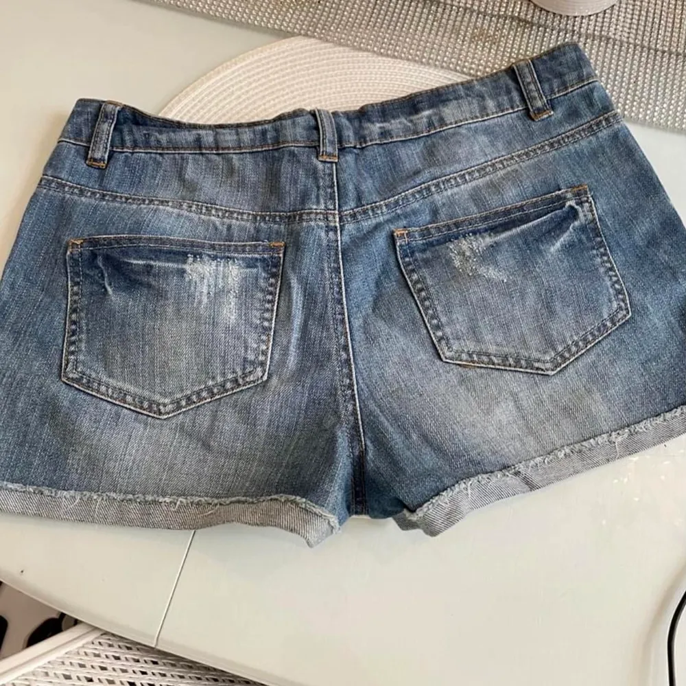 Snygga stretchiga jeansshorts med kant och snygga slitningar. Färg: blå/vita Stlk:38 (M). Shorts.
