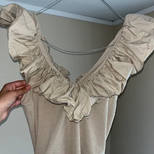 Beige klänning med volanger - Beigefärgad klänning med volanger, medellång i fint skick, använd endast en gång 