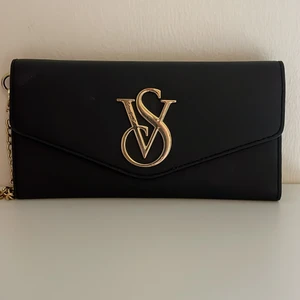 Väska i svart och guld - Väska från Victorias Secret i svart och guld. Kan mötas i Malmö annars står köparen för frakten 