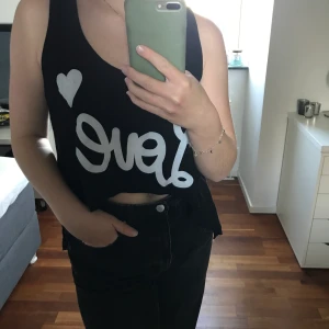 Linne - Svart linne med tryck på i storlek XS/S. Lite defekt vilket syns på bild 3. 