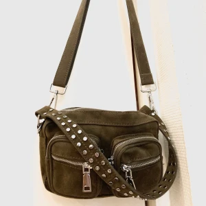 Noella kendra väska army green - Säljer noella kendra väskan i fint skick, inköpt för ett par veckor sedan och endast använd 5-6 tillfällen. Det långa bandet är avtagbart. Mått: höjd 10 cm, bredd 15 cm, djup 4 cm.  Köparen betalar för frakten. Hör av er vid frågor! 🥰