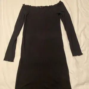En svart offshoulder klänning som är tight fitted! har använts 1 gång! ❤️