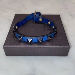Valentino armband  - Bra skick, använd par tal gånger. Färg blå, ny pris ca 1800. Låda, dustbag och extra nitar ingår.
