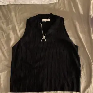 En svart tröja/linne från H&M med dragkedja. Tvättat i parfymfritt tvättmedel.