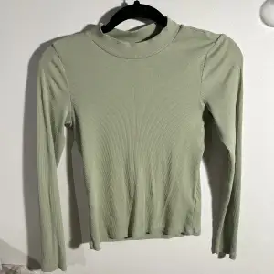 Grön långärmad tröja med halvpolo från Monki i storlek S. På sista bilden ser ni tröjan i en annan färg för att visa passformen bättre 😇