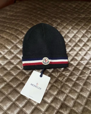 Moncler mössa  - Helt ny moncler mössa som håller dig varm under vintern!! Nfc finns, scan finns och tags medföljer  Skriv gärna för fler frågor:)
