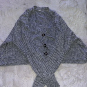 Grå Stickad Topp Med Knappar Storlek M - En grå stickad topp med knappar. Skönt material. Visar magen. Använd en gång. Storlek M.