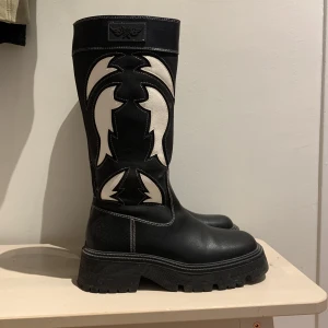 Höga platåstövlar - Höga stövlar med platå, fyrkantig tå och westernmönster. Använda 1 gång utomhus, så inga slitskador utan endast dammiga/smutsiga. Inköpta för 600 kr. Upphämtning/möte prioriteras 🧚🏼 kom gärna med prisförslag!