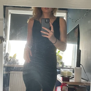 Grön festklänning i velvet  - Grön halvlång festblåsa i velvet med volangfåll i storlek m