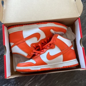 Dunk high Syracuse  - Dunk high syracuse är en unik colorway som inte säljs längre. Väldigt gott skick och nyligen rengjorda. Använda ca 3 gånger endast pga för små i storleken för mig. Kvitto medföljer! Skriv för mer bilder eller frågor!