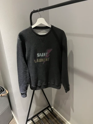 Saint Laurent sweatshirt  - Tröjan är i bra skick inga skador eller liknande, storlekM, pris:1400kr frakt 69kr, mer bilder finns i dm tyvärr tappat bort kvittot🤝🏻😊
