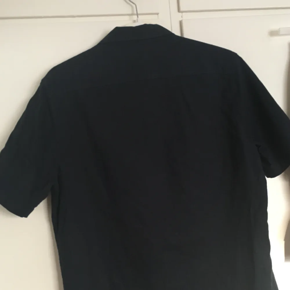 Marinblå (nästan svart) skjorta i bomull från H&M. Sparsamt använd & i gott skick. Herrstorlek S så relativt långsmal modell. Priset inkluderar frakt, meddela vid frågor!. Skjortor.