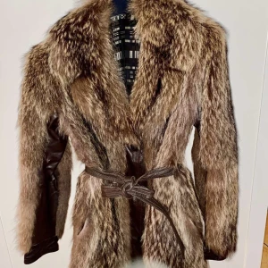 Vargpäls jacka. St - En väldigt fin vargpäls-jacka/kårt kappa.  Jackan är i välskött skick och har läder detaljer i brun färg,vid medjebältet,armsluten och några centimeter runt om jackans slut. Storlek S.  