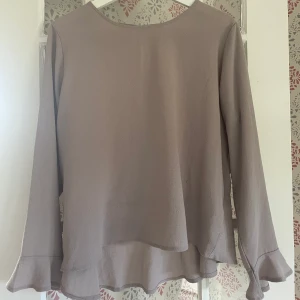 Tröja/Blus från only - Beige/brun tröja från ”Only” i storlek 40, sitter löst och är ganska stor i storlek så skulle säga att även en 38 kan använda 😁 I använt skick men ser fräsch och fin ut, inga synliga fläckar eller hål 🤩Väldigt fin detalj med volang på ärmen, se bild 3!