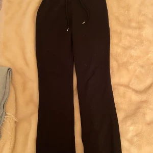 Svarta utsvängda mysbyxor Nelly - Svarta utsvängda mysbyxor med snörning. Storlek XS. Har många byxor i denna modell som jag ej behöver. Använder dessa byxor ofta då de är såå sköna!💕Om ni är intresserade av hur dessa ser ut på, fråga så visar jag🥰