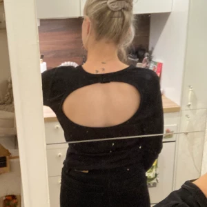 Svart tröja med urringning på ryggen stolek M - Snygg enkel topp med urringning på ryggen från ginatricot. Vågigt längst ner på ärmarna samt nedtill av tröjan. Kan skicka mer bilder :) 
