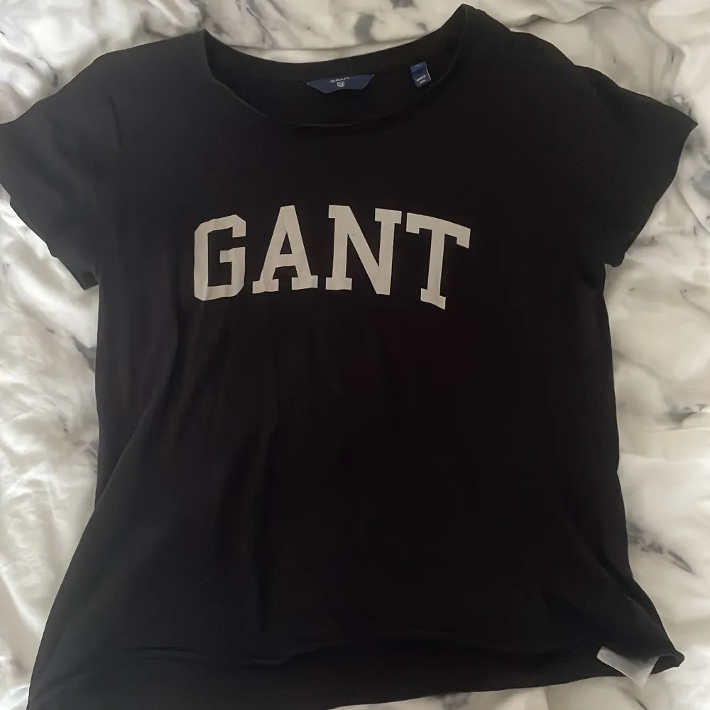 En mörkblå GANT T-Shirt med vitt tryck i storlek S. T-shirts.