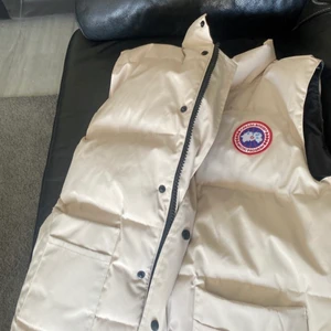 Canada Goose väst  - Äkta canada Goose väst färgen beige/vit sprillans ny storlek L byter den mot en Gucci keps oxå 