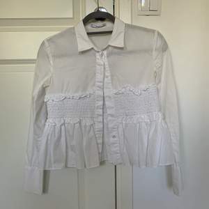 En vit skjorta med volanger i srl Xs från Mango. Väldigt fin och unik. Frakt tillkommer!