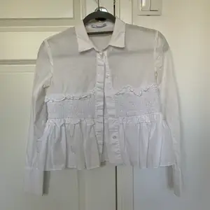 En vit skjorta med volanger i srl Xs från Mango. Väldigt fin och unik. Frakt tillkommer!