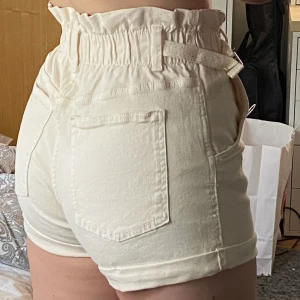 Ljusbeiga/vita shorts - Ett lag ljusbeiga/vita shorts från Bershka i storlek 38. Lite detaljer på sidorna, väldigt fina och sköna. Aldrig använda