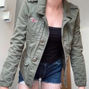 Hollister jacka S - Grön hollister jacka som endast är använd ett fåtal gånger. Snöre i midjan som man knyter därbakom. Skriv vid frågor🥰