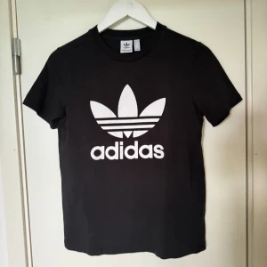 Svart Adidas T-Shirt med tryck - Svart adidas t-shirt i nyskick, använts nån gång. Storlek 38, passar S/M beroende på kroppsform. 