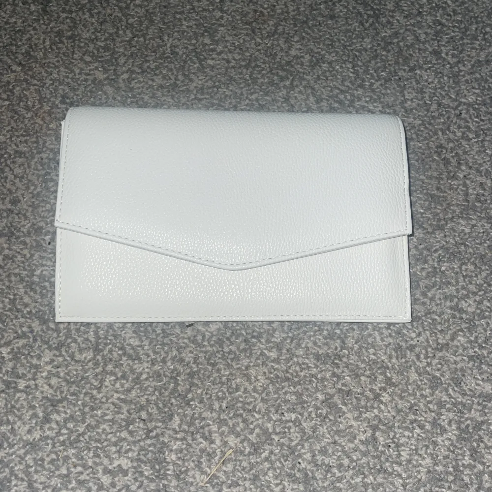 Säljer denna vita kuvertväska, säljer pågrund av att den inte kommit till användning.. Väskor.