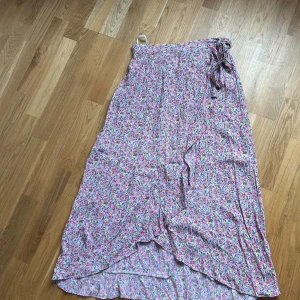 Blommig wrapkjol, PIECES, strl L - Blommig kjol, har en wrap utseende men sitter helt ihop.  Resår i bak Storlek L