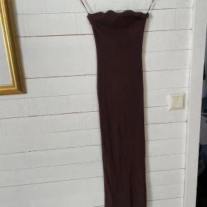 Bershka tubklänning - Brun lång tubklänning från bershka🤎 Knappt använd och i nyskick! Storleken är XS men passar likaväl mig som vanligtis har S. Nypris 259 kr och säljer för 100❤️ (Köpare står för frakt)