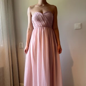 Balklänning - dusty pink  - Säljer min vackra hellånga brudtärneklänning som endast är använd på ett bröllop. I färgen dusty pink/ljusrosa med smock i ryggen. 