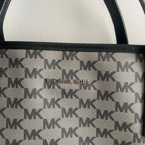 Michel Kors väska - En snygg Michel Kors dataväska! Den är väldigt praktiskt och i jättebra skick. Det tjocka axelbandet går att sätta på och av.💕orginalpris är runt 2000. Pris kan alltid diskuteras!
