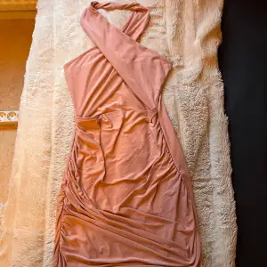 Super fin puder rosa klänning med korsad halter neck från märket missy empire från Asos. Använd en gång, nyskick.