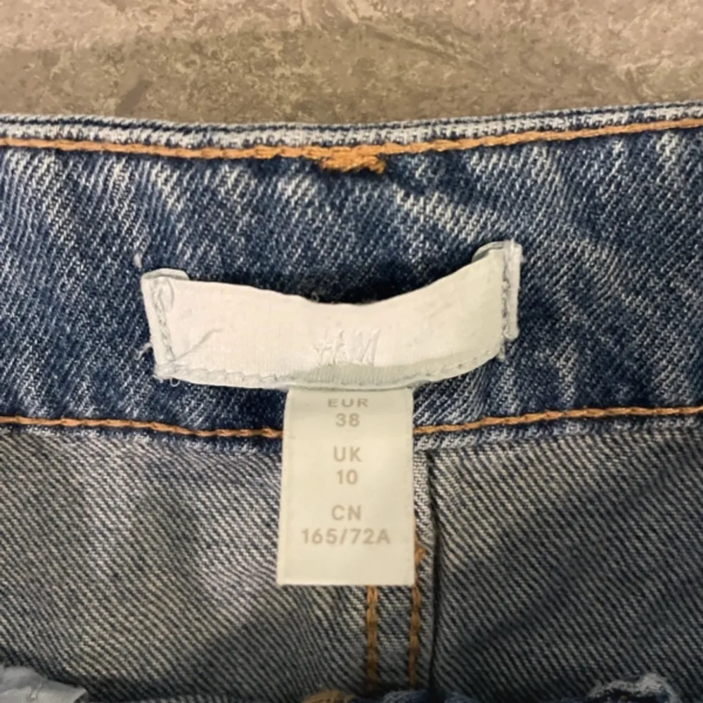 Ett par mörkblåa high waist jeans i storlek 38, köpt på H&m för nått år sedan, jeansen har hål som ni kan se på bilderna, sitter fint där bak. Jeans & Byxor.