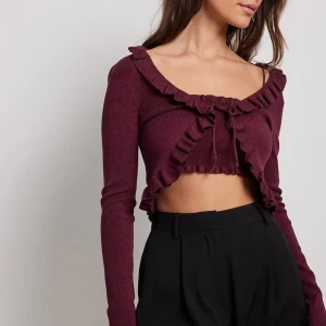 Cardigan - OANVÄND! Vinröd/burgundy, lite glittrig, cardigan med fina detaljer från NA-KD✨ Storlek L, dock liten i storleken, passar därför både större o små: de som vanligtvis bär XS, S, M, L❤️ Helt slutsåld, köptes för 399kr! Helt ny, alla lappar sitter kvar!