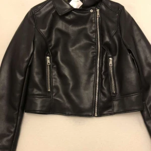 Svart läderjacka - Helt nytt och oanvänd, prislappen är kvar. Strl 38 så passar strl S. Nypris runt 190kr så säljer den då för 100